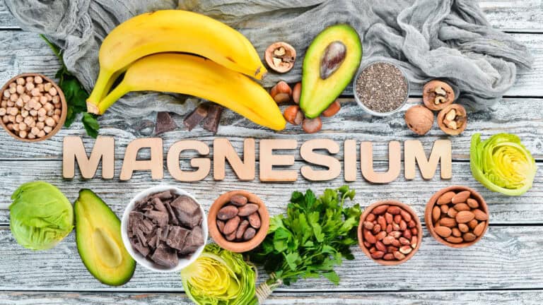 Various foods rich in magnesium with the word "magnesium" displayed prominently in the center.