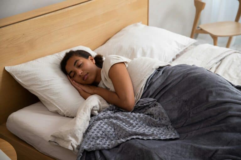 A person sleeping peacefully in bed with a blanket.